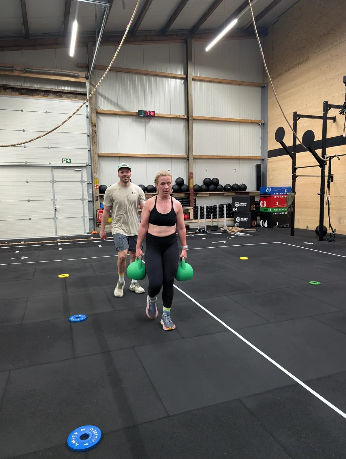Farmers Carry mit Kettlebells auf der markierten Bahn — HYROX Training bei AMITY Athletics in Dülmen
